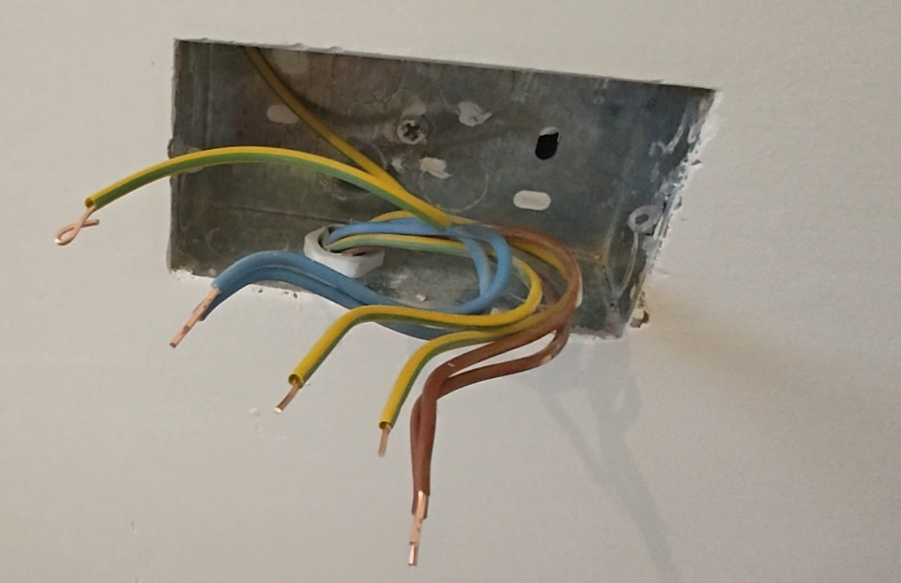 Wiring a double UK wall socket showing brown live and blue neutral wires connected to terminals.